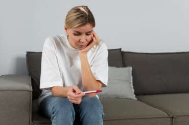 A woman in a clinic discussing her contraceptive choices with a friendly female doctor.